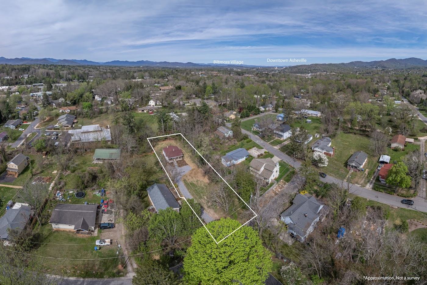 Aerial view with the property boundary outlined, mountains in the distance
