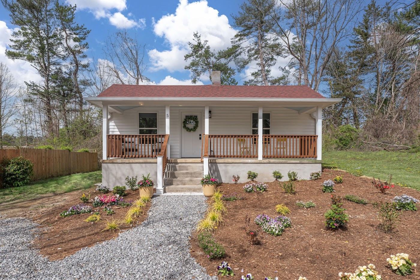 5 White Avenue, straight-on view of the white cottage with its full-width covered porch and new landscaping